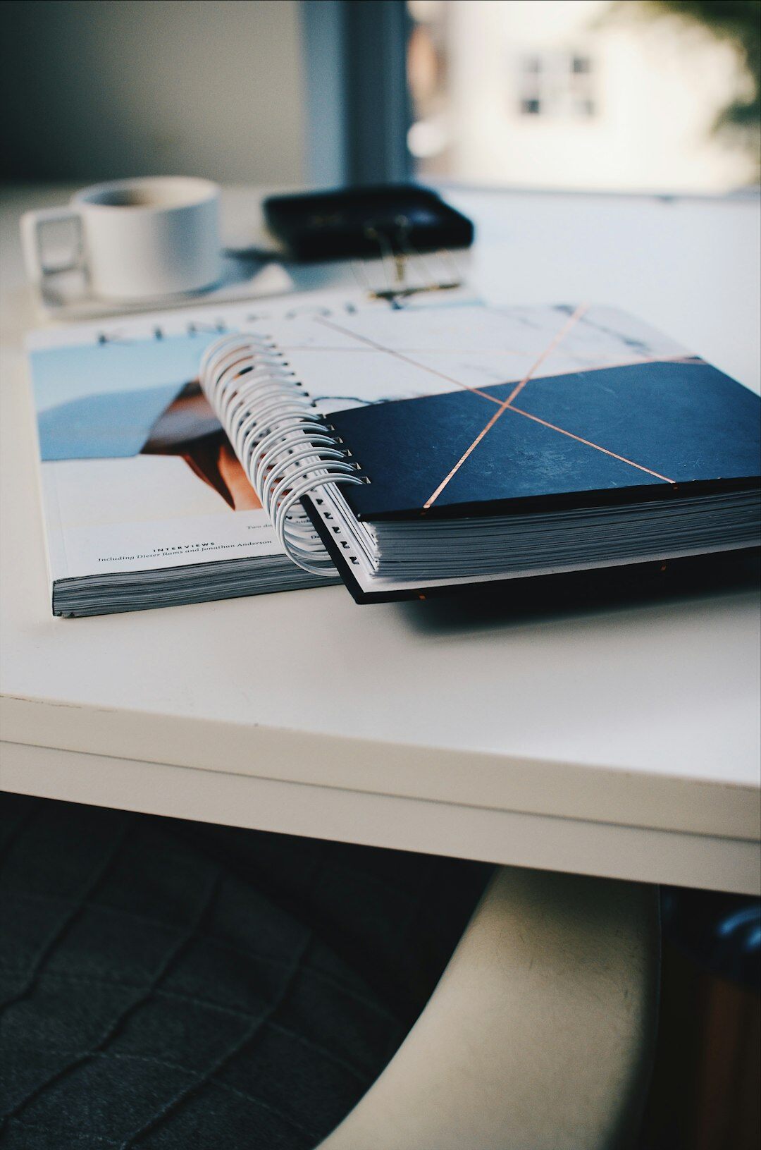Desk with printed research reports, notebook and a laptop showing data charts